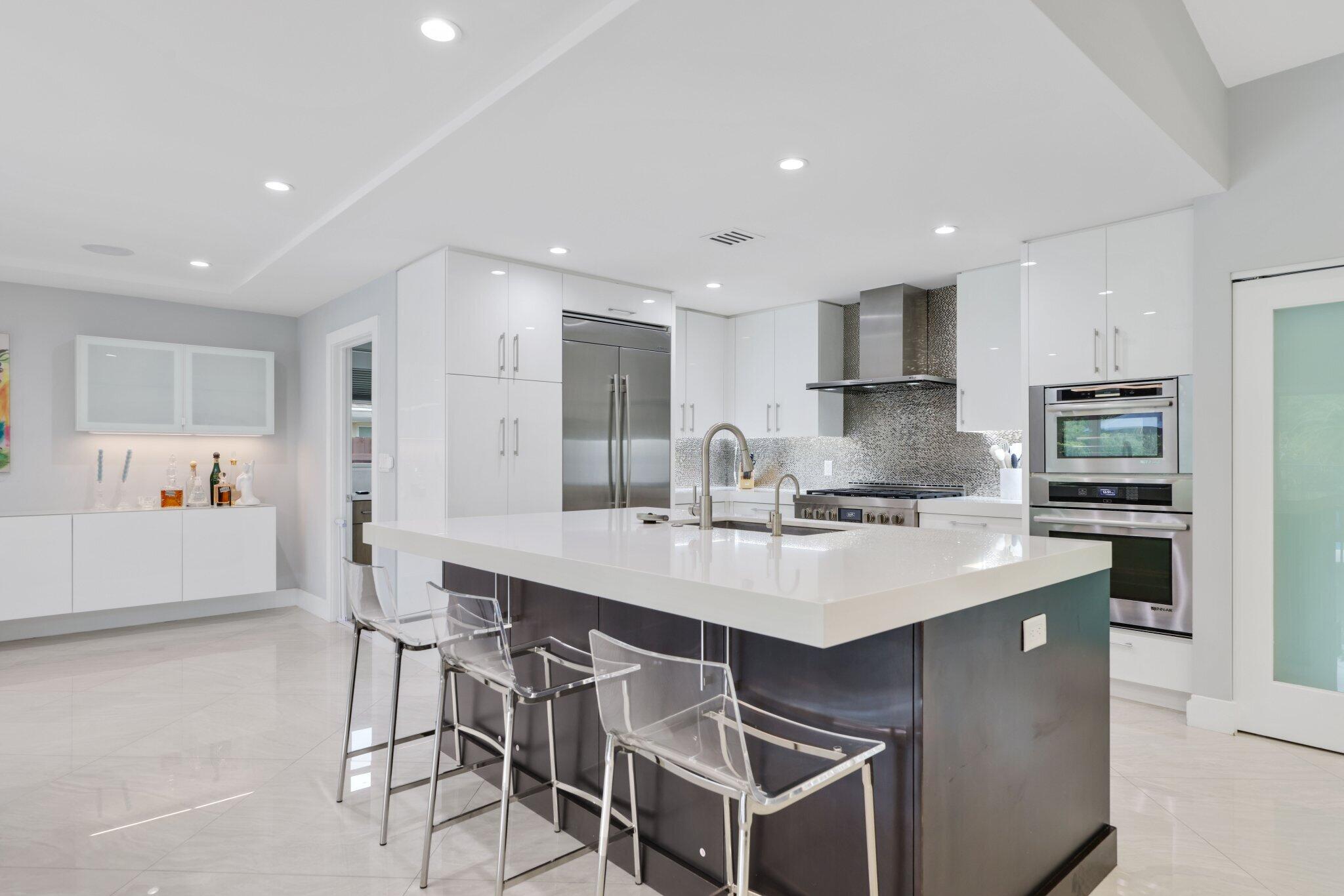 20984 Shady Vista Lane Boca Raton, FL 33428 - Photo 13 of 54 a large white kitchen with kitchen island a table and chairs in it