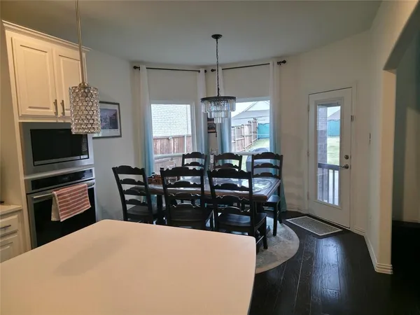 a kitchen with stainless steel appliances a dining table chairs and granite counter tops