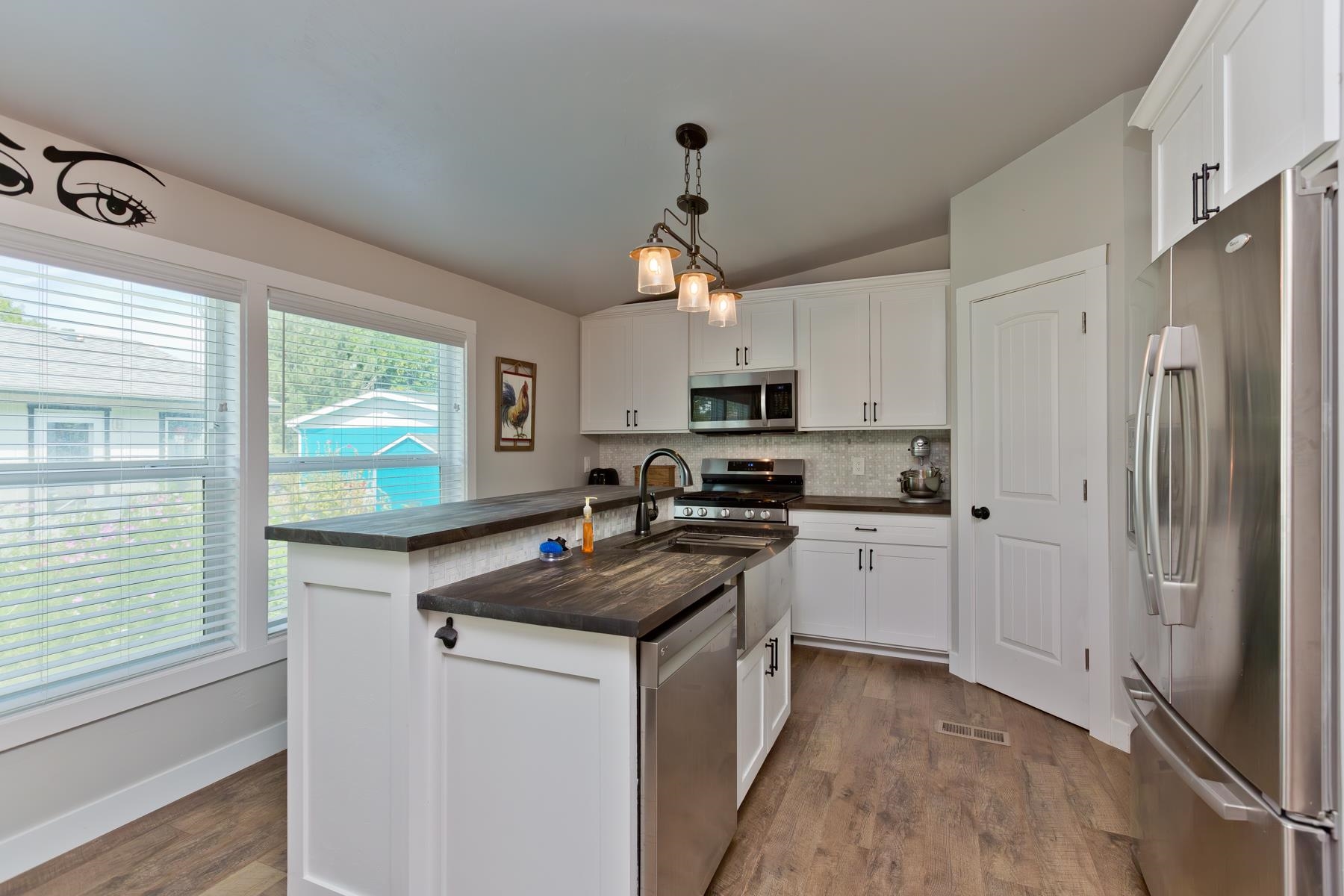 435 32 Road, Unit 601 Clifton, CO 81520 - Photo 11 of 38 a kitchen with a refrigerator a stove a sink and white cabinets with wooden floor