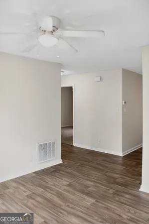 a view of an empty room with wooden floor