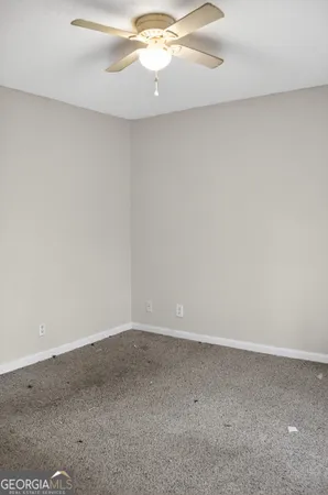 an empty room with a chandelier fan