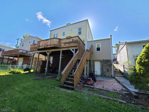 a view of a house with a wooden deck and a yard
