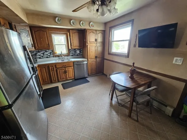 a kitchen with stainless steel appliances granite countertop a refrigerator a sink a stove and white cabinets