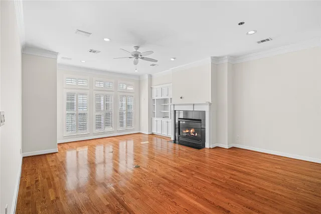 a view of empty room with wooden floor and fireplace