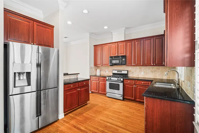 a kitchen with stainless steel appliances granite countertop a refrigerator stove microwave and sink