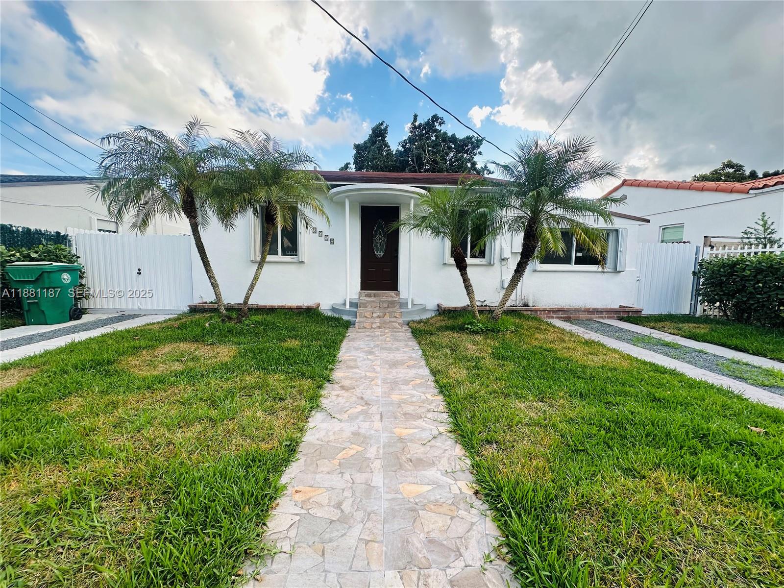 3052 Southwest 6th Street Miami, FL 33135 - Photo 1 of 15 a front view of a house with a garden and palm trees