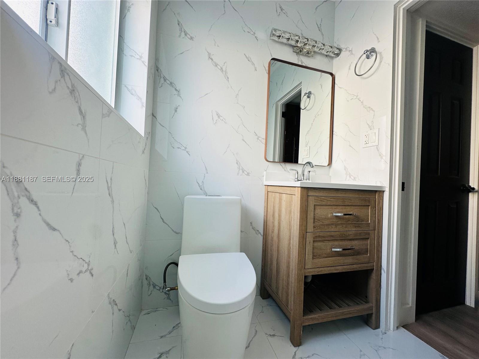 3052 Southwest 6th Street Miami, FL 33135 - Photo 13 of 15 a bathroom with a toilet sink and mirror