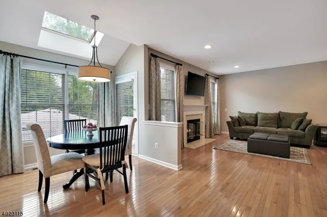 a living room with furniture a large window and wooden floor