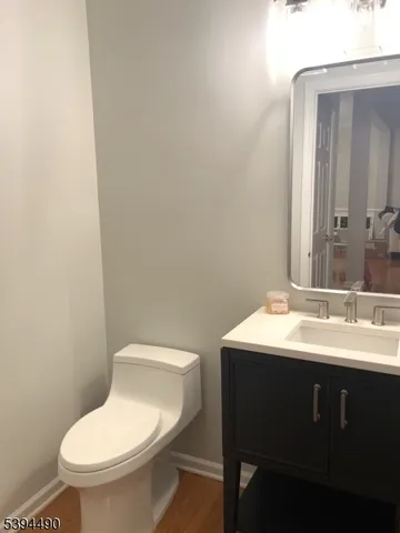 a bathroom with a toilet a sink and mirror