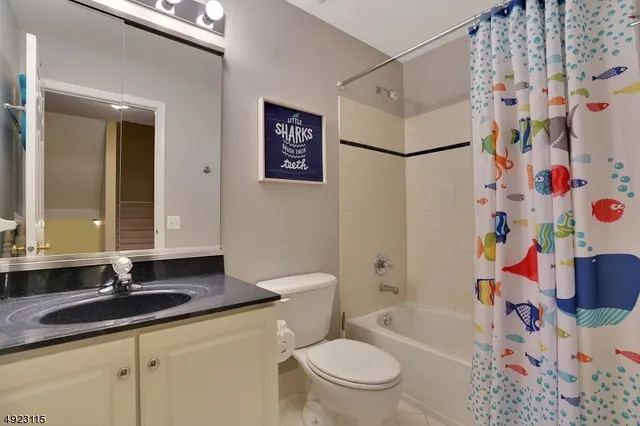 a bathroom with a sink a toilet and a shower curtain