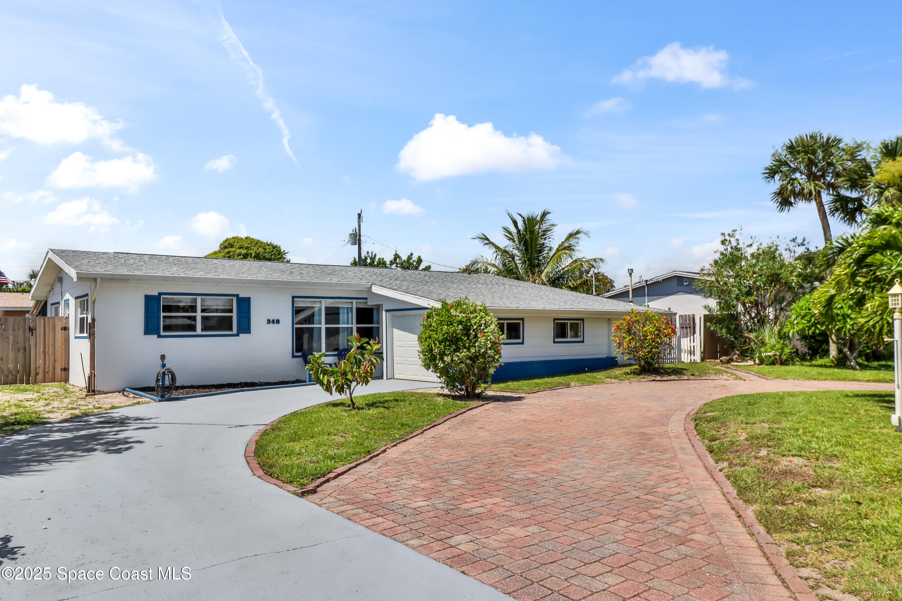 348 Berkeley Street Satellite Beach, FL 32937 - Photo 1 of 46 a front view of a house with a yard and garage