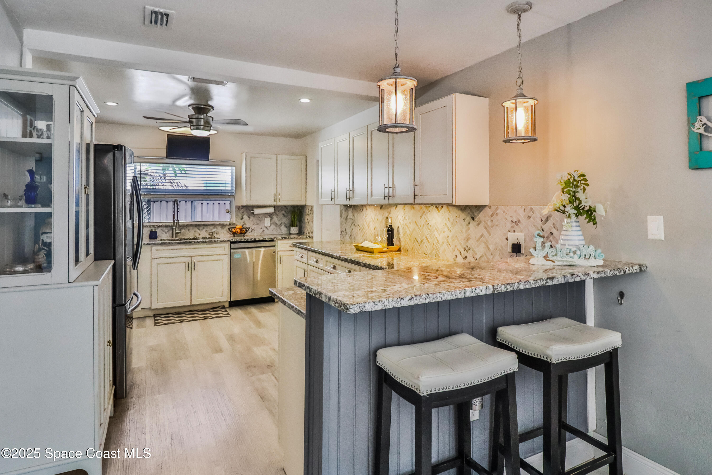 348 Berkeley Street Satellite Beach, FL 32937 - Photo 14 of 46 a kitchen with kitchen island a wooden floor and white appliances