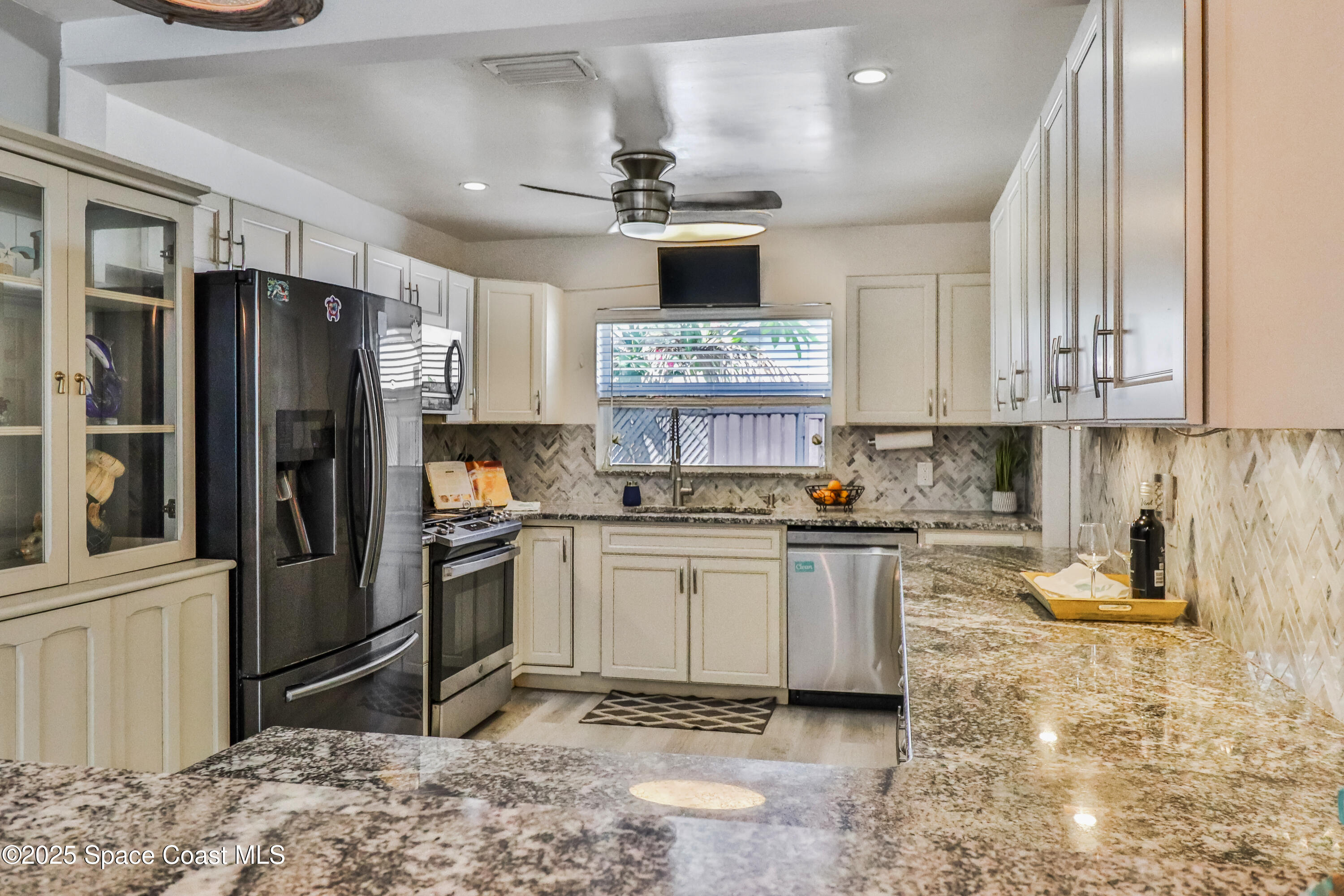 348 Berkeley Street Satellite Beach, FL 32937 - Photo 15 of 46 a kitchen with stainless steel appliances granite countertop a refrigerator stove and sink