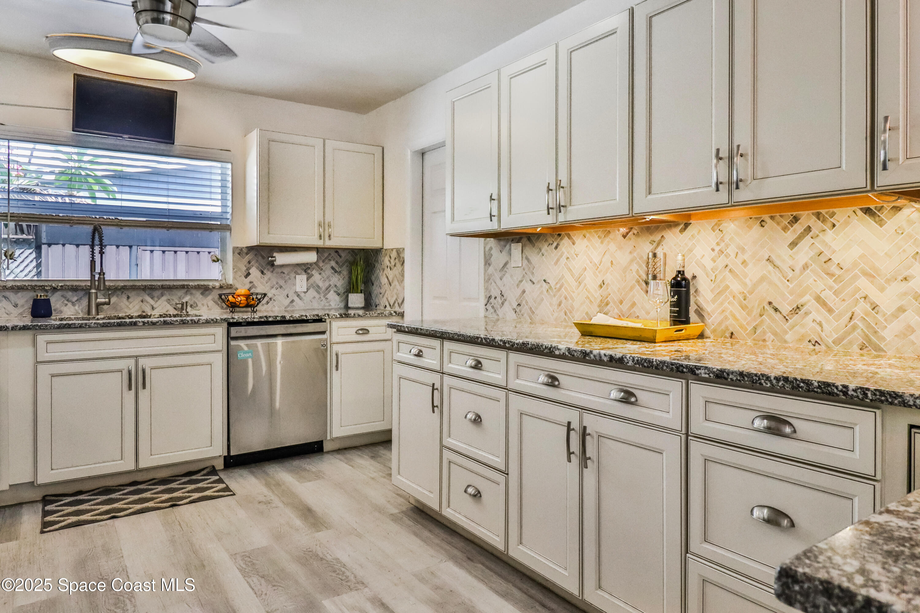 348 Berkeley Street Satellite Beach, FL 32937 - Photo 16 of 46 a kitchen with white cabinets and white appliances