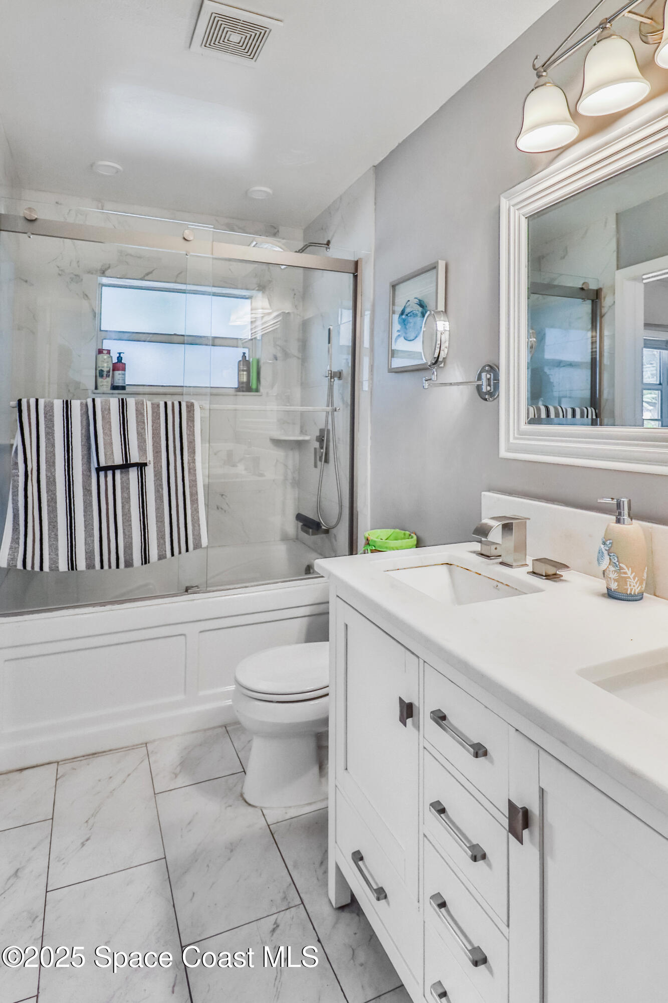 348 Berkeley Street Satellite Beach, FL 32937 - Photo 24 of 46 a bathroom with a granite countertop sink mirror vanity and toilet