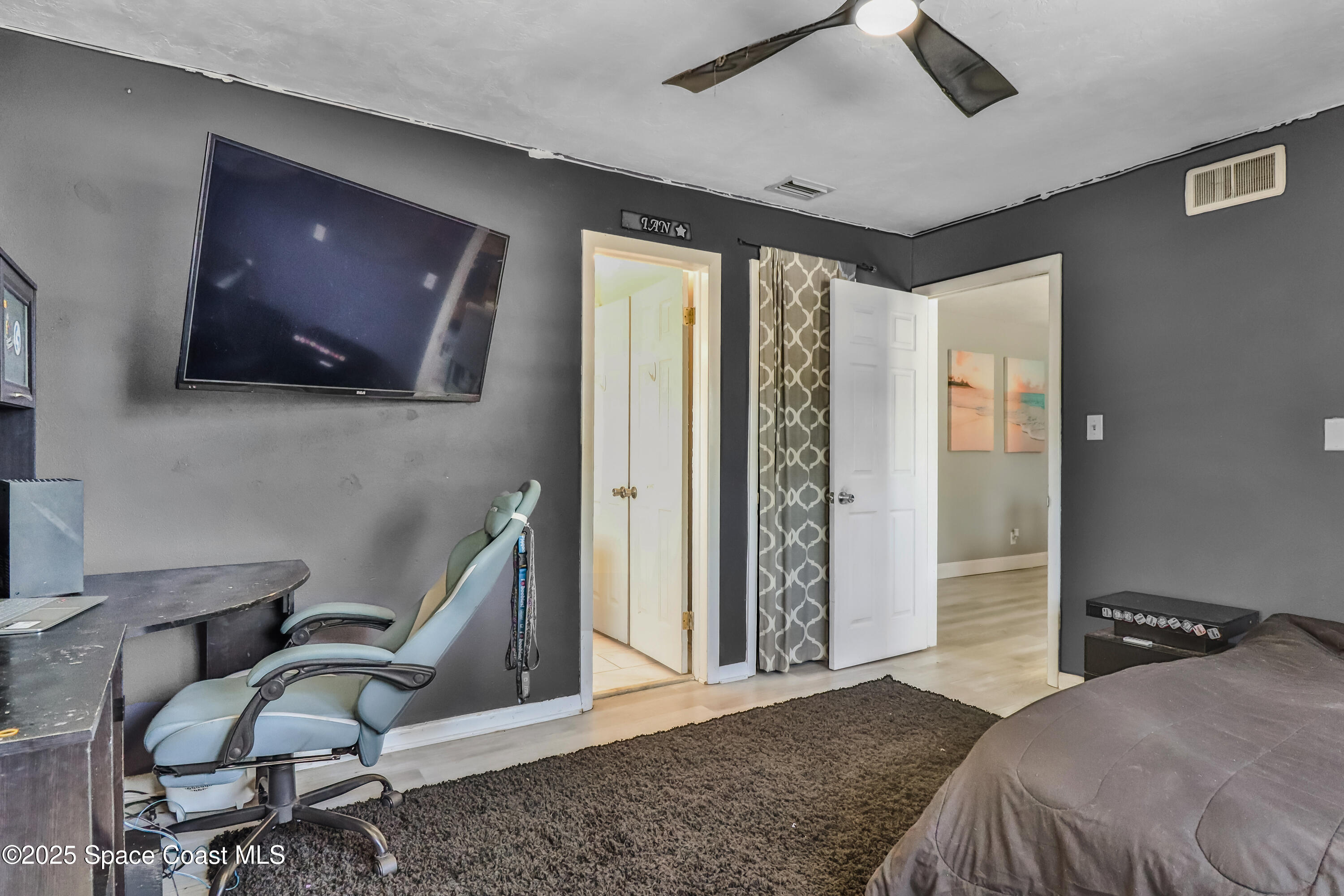 348 Berkeley Street Satellite Beach, FL 32937 - Photo 27 of 46 a bedroom with furniture and a flat screen tv