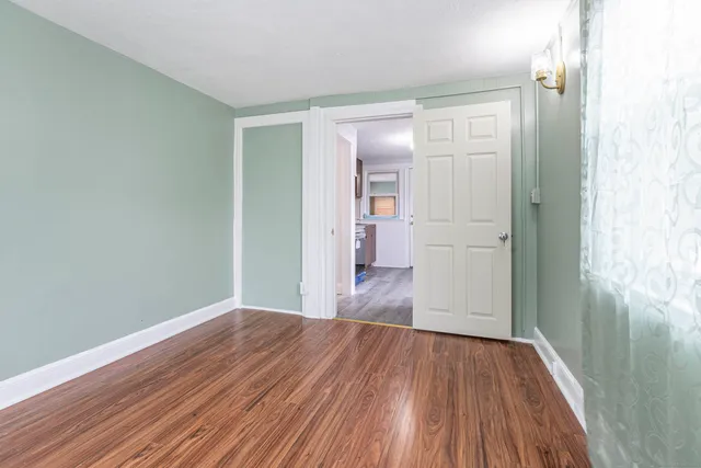 a view of a room with wooden floor and a bathroom