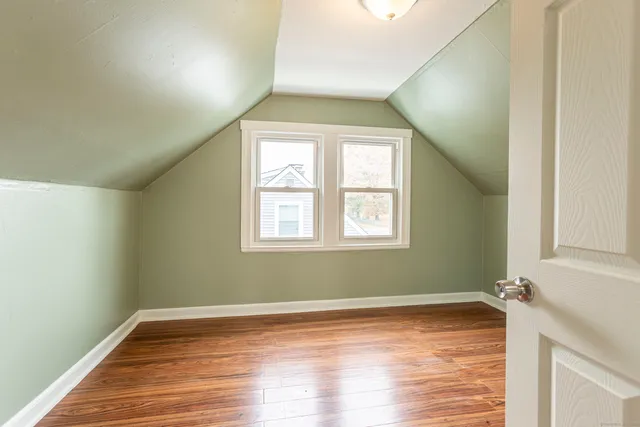 a view of a room with wooden floor and a window