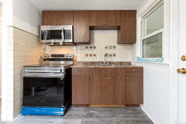 a kitchen with stainless steel appliances a stove a sink and a microwave
