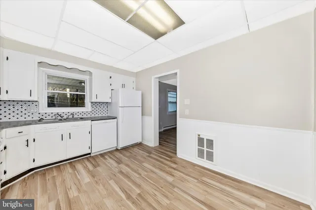 a view of a hallway with wooden floor and a living room