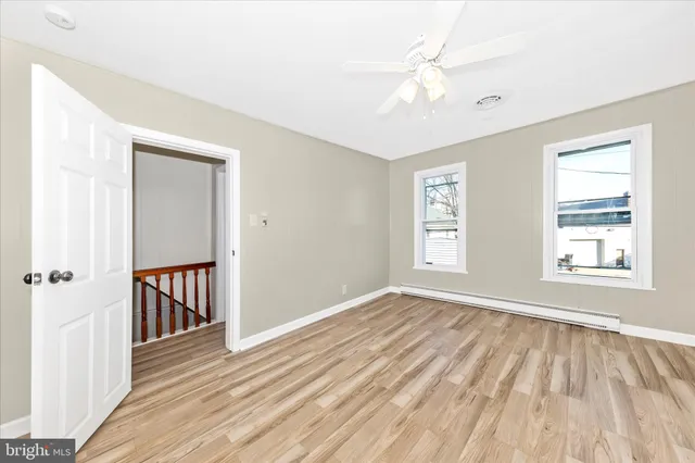 an empty room with a window and a ceiling fan