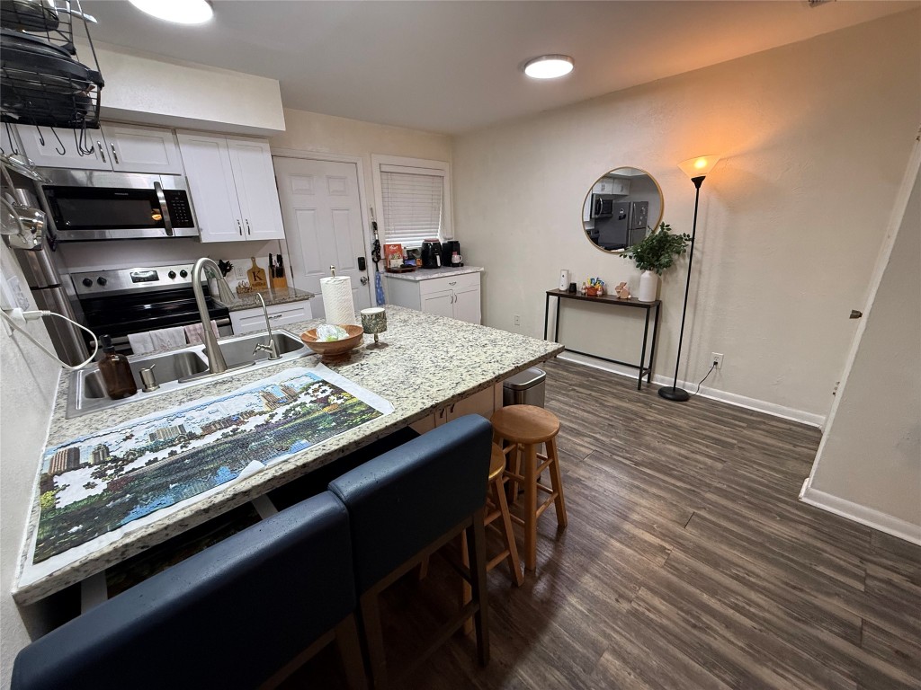 2413 Leon Street, Unit 108 Austin, TX 78705 - Photo 16 of 22 a kitchen with stainless steel appliances granite countertop a stove refrigerator and cabinets