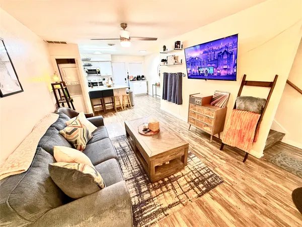 a living room with furniture and a wooden floor