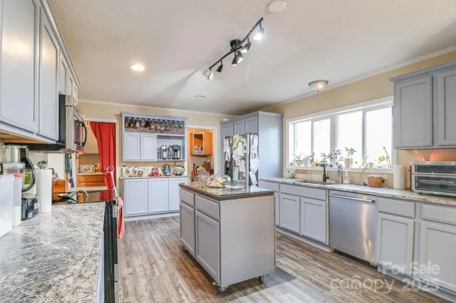 a kitchen with stainless steel appliances granite countertop a lot of counter space and wooden floors