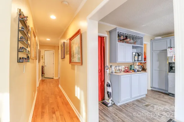 a view of hallway with wooden floor and cabinet