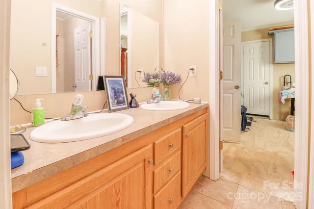 a bathroom with a double vanity sink a mirror and a bathtub
