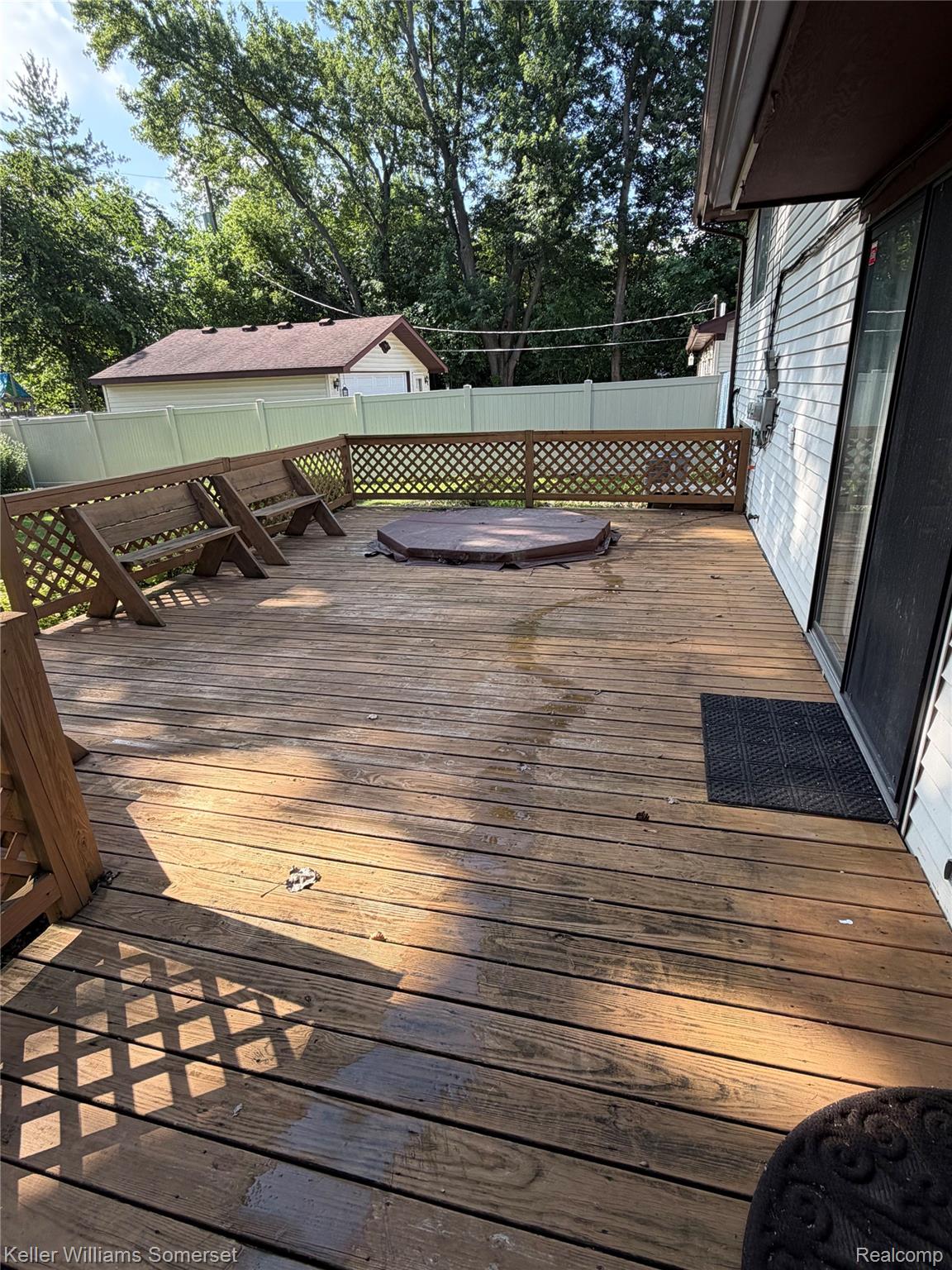 3277 Eastern Avenue Rochester, MI 48307 - Photo 12 of 13 Expansive wood-finish deck with built-in bench seating, lattice railing, and an integrated spa