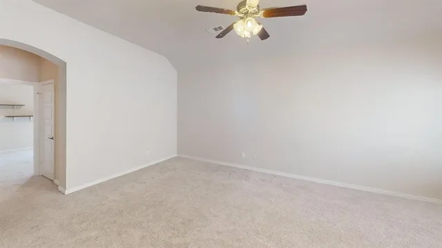 an empty room with a chandelier fan