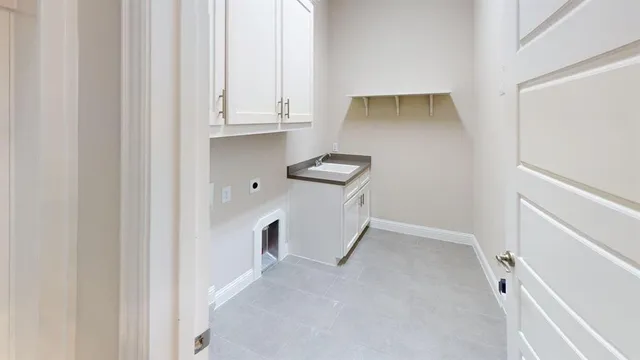a view of cabinets and utility room with closet