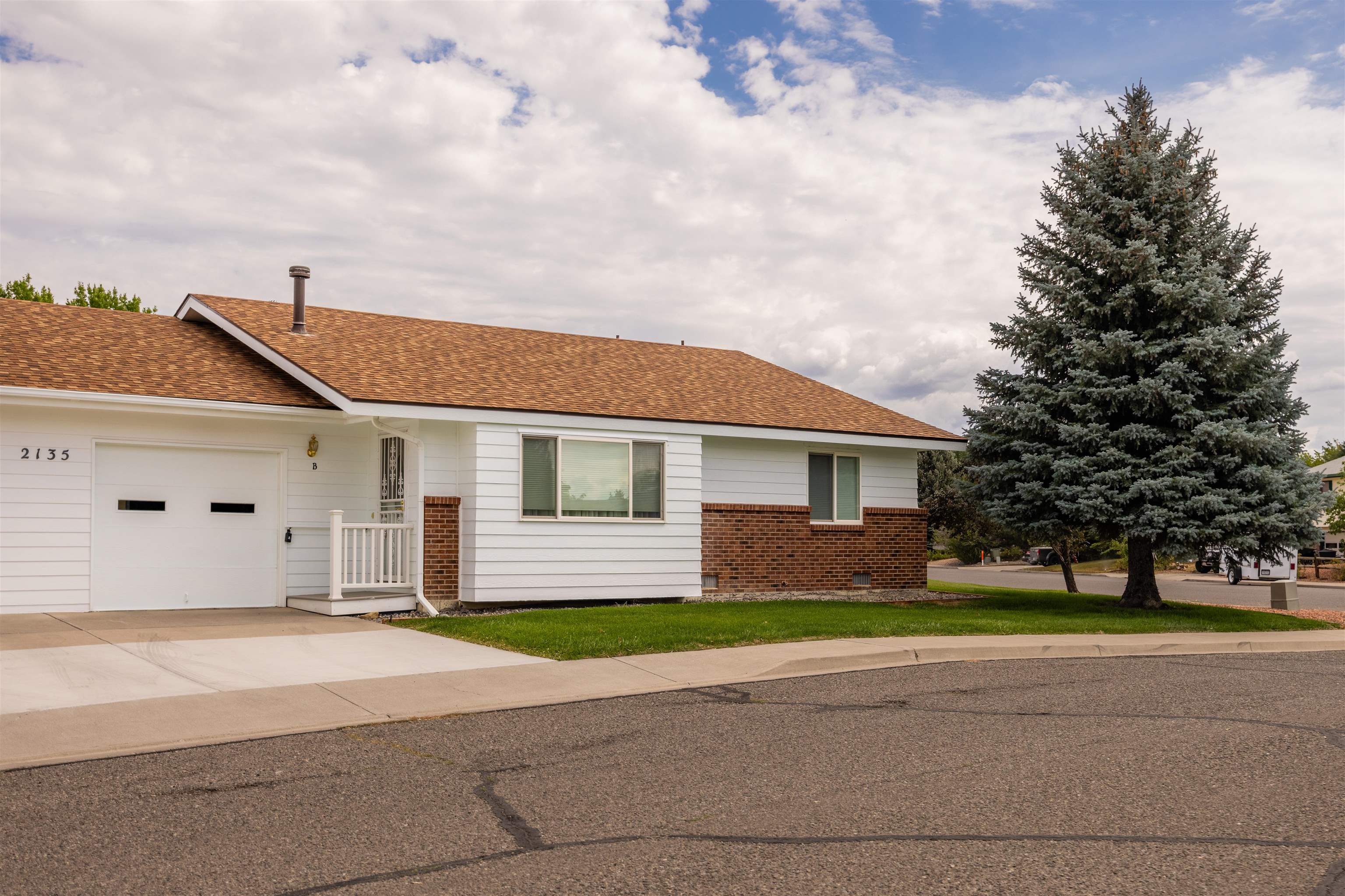 2135 Winston Way, Unit B Montrose, CO 81401 - Photo 2 of 23 a front view of a house with a yard and garage