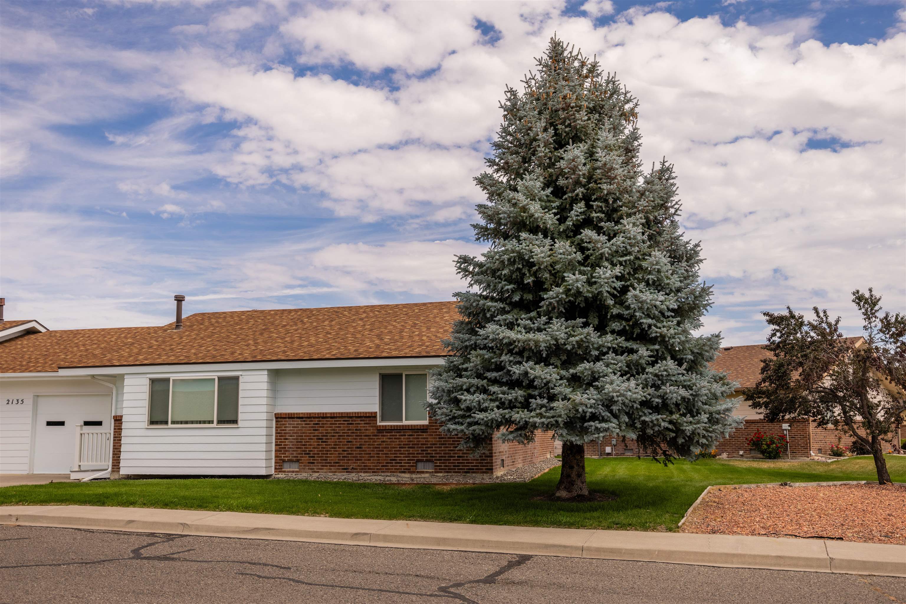 2135 Winston Way, Unit B Montrose, CO 81401 - Photo 3 of 23 a front view of a house with a garden and trees