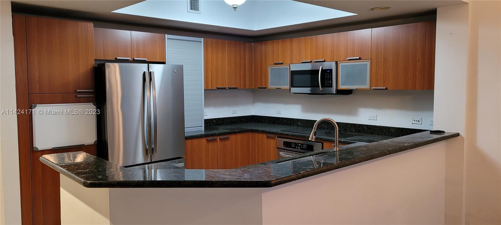 2650 Lake Shore Drive, Unit 2202 Riviera Beach, FL 33404 - Photo 13 of 29 a kitchen with stainless steel appliances granite countertop a refrigerator a stove and a sink with wooden floor