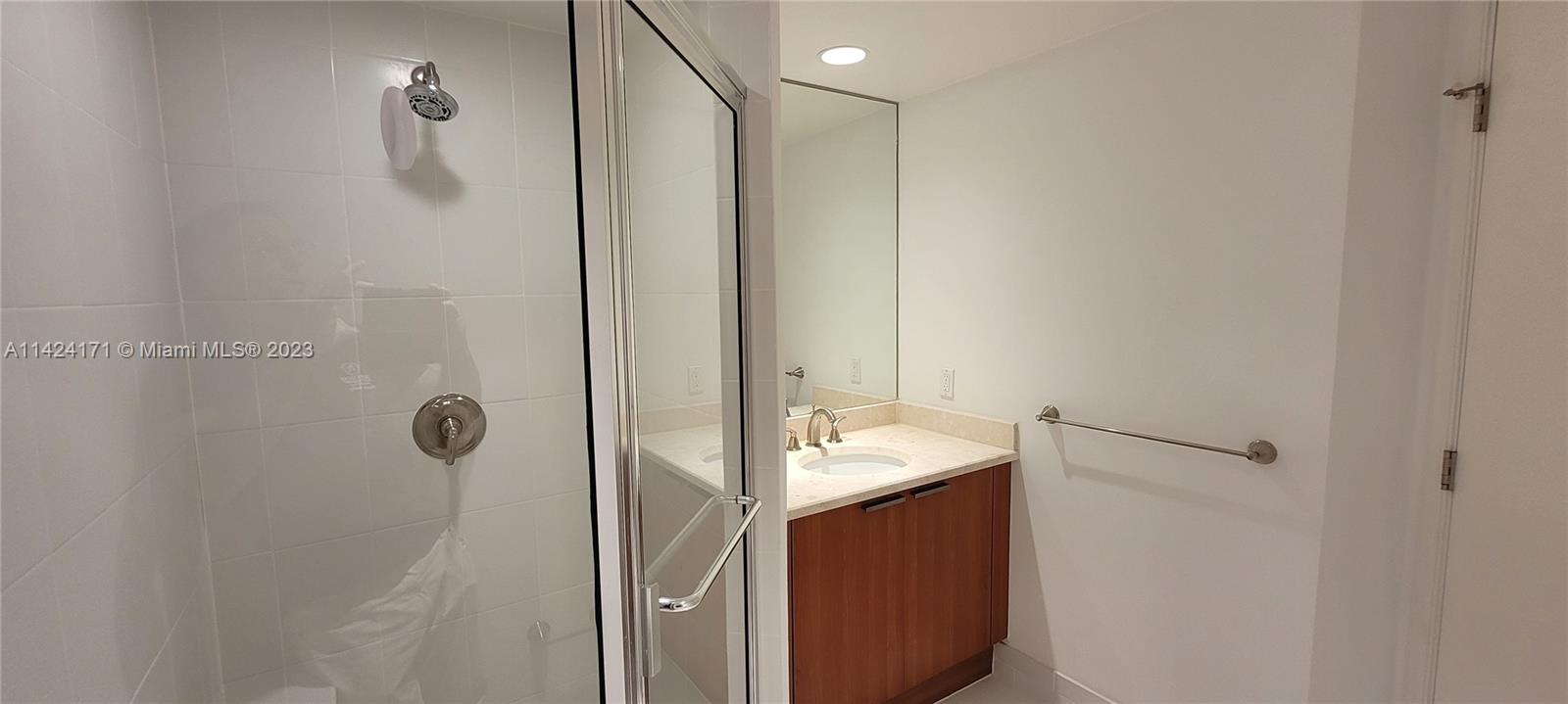 2650 Lake Shore Drive, Unit 2202 Riviera Beach, FL 33404 - Photo 16 of 29 a bathroom with a granite countertop shower sink vanity and mirror