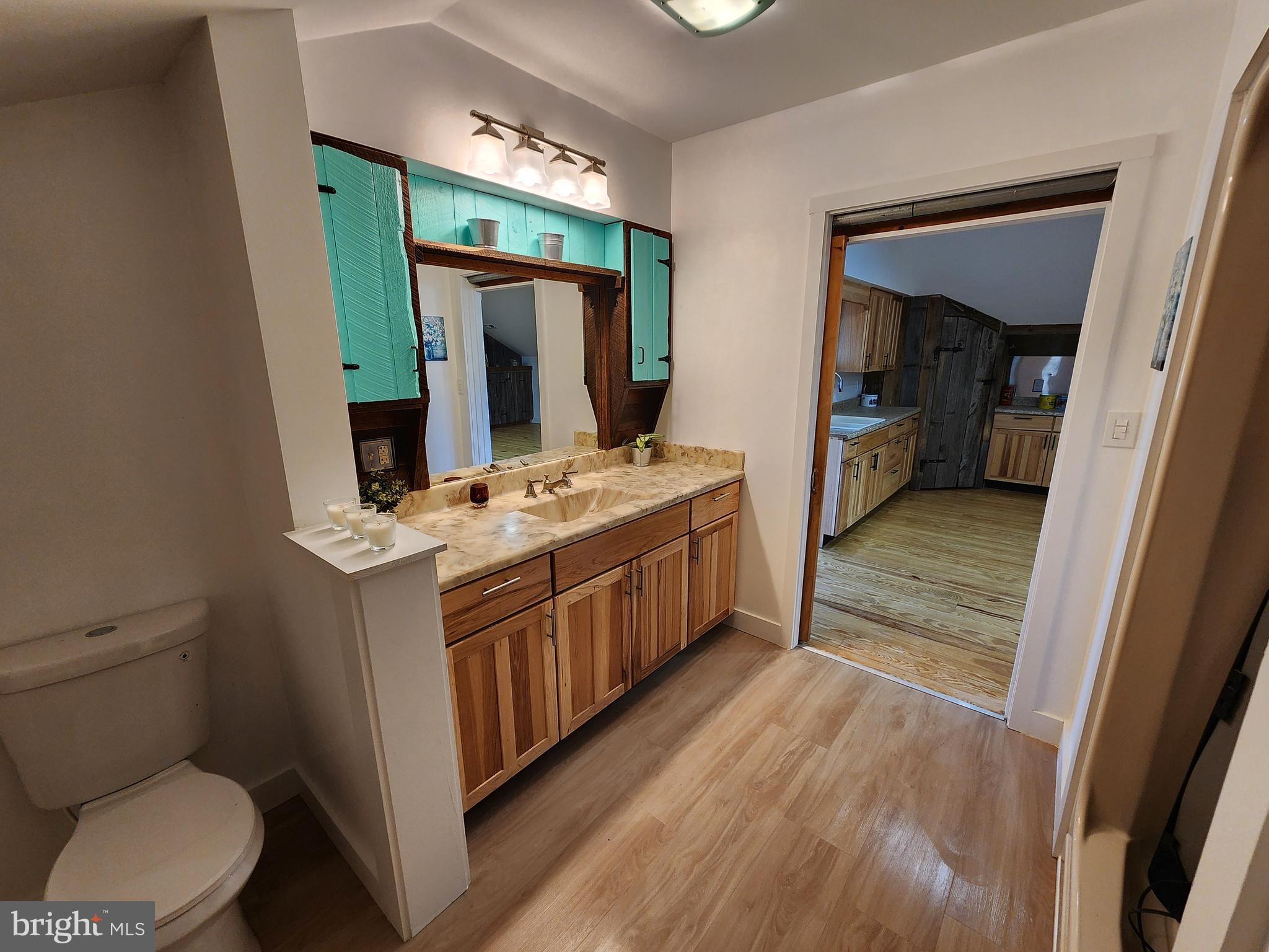 6366 Galestown-Reliance Road Federalsburg, MD 21632 - Photo 22 of 55 a kitchen with stainless steel appliances a stove a refrigerator and a wooden floor