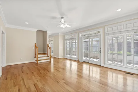 an empty room with windows and fan