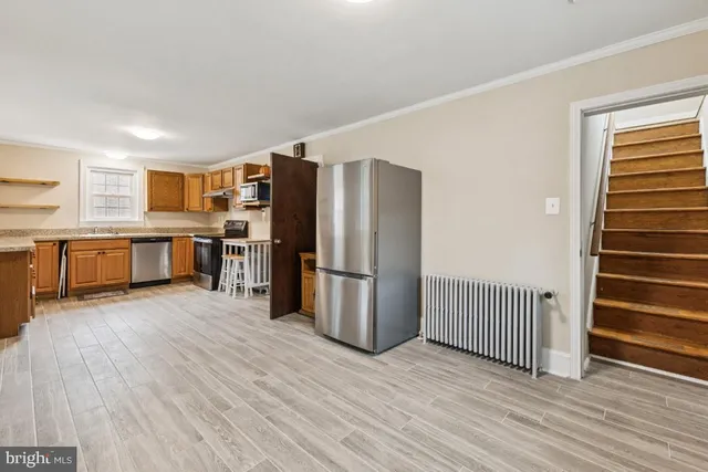 a kitchen with stainless steel appliances a refrigerator and wooden cabinets
