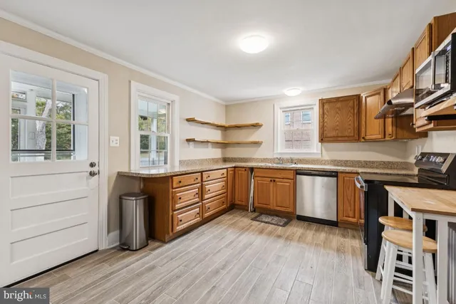 a kitchen with stainless steel appliances kitchen island granite countertop a stove and a sink