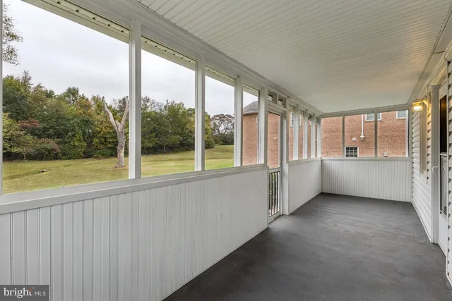 a view of a big room with wooden floor and windows
