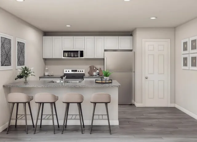 a kitchen with stainless steel appliances white cabinets and chairs