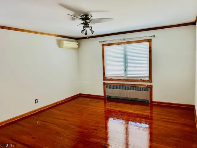 a view of room with hardwood floor and ceiling fan