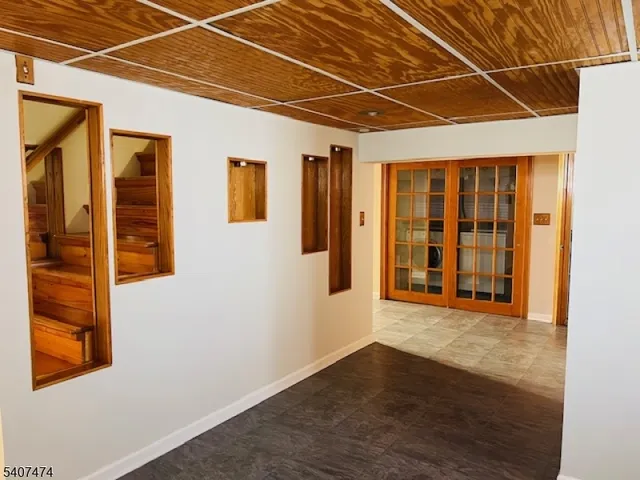 a view of an empty room with wooden floor and windows