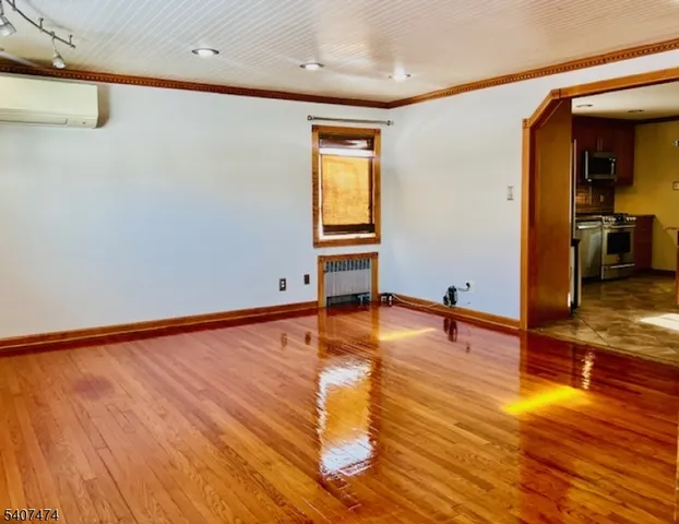 a view of empty room with wooden floor