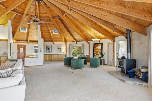 a view of a dining room and livingroom with furniture wooden floor a chandelier
