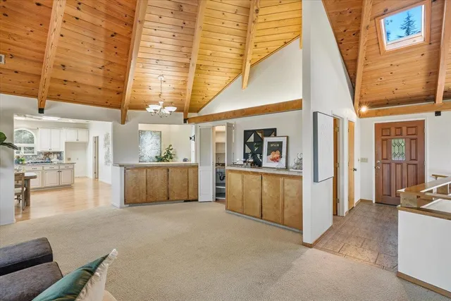 a kitchen with stainless steel appliances kitchen island granite countertop a stove a refrigerator a sink a dining table and chairs with wooden floor