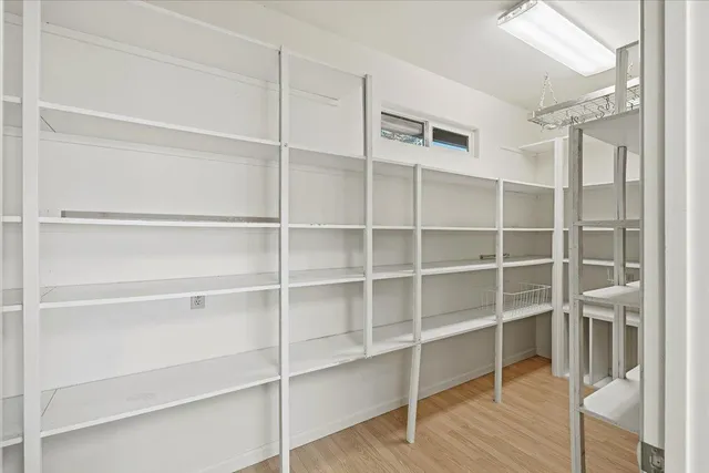a view of an empty room with wooden floor and windows