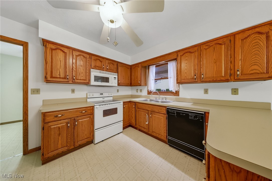425 Overlook Drive Rittman, OH 44270 - Photo 17 of 44 Kitchen featuring brown cabinetry, white appliances, light floors, and light countertops